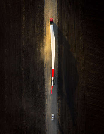 Turbine bladesfor a wind turbine being transported to the construction site by truckの写真素材