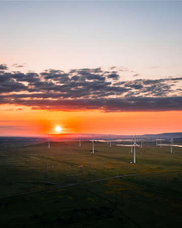Wind turbine farm at sunset. Renewable energy conceptの写真素材