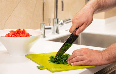 Cutting bunch of fresh dill on plastic cutting board. white styleの写真素材