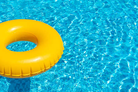 Yellow ring floating in refreshing blue swimming poolの写真素材