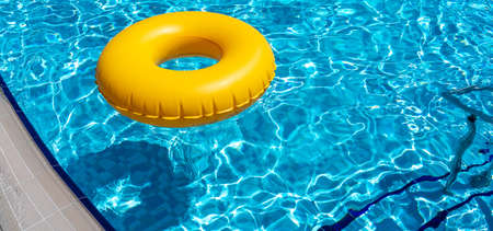Yellow ring floating in refreshing blue swimming poolの写真素材