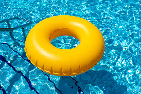 Yellow ring floating in refreshing blue swimming poolの写真素材