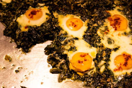 Heated buffet container with Over easy eggs with Spinach and Garlicの写真素材