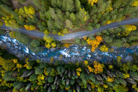 Top view of mountain road in forest with blue riverの写真素材