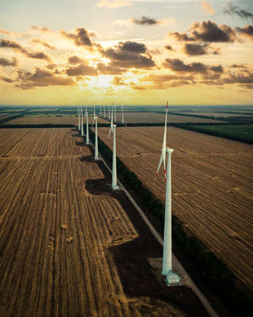 Wind turbine farm at sunset with dramatic sky. Producing alernative energy. Renewable energy concept.の写真素材
