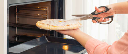 Opening a pizza bag before baking in the ovenの写真素材