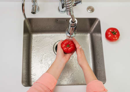 vegetables are washed under water close-up brightの写真素材