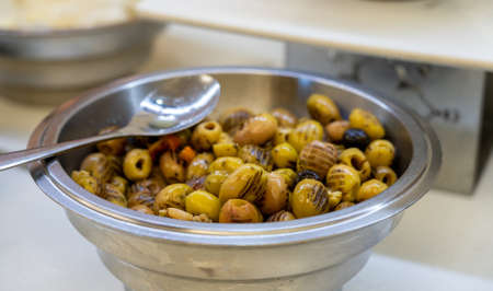 Closeup of grilled marinated green olives in bowl on tableの写真素材