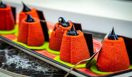 Small cone-shaped velveteen cakes decorated with chocolate pasteの写真素材