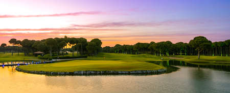 Sunset at the golf course. Scenic panoramic view of golf fairwayの写真素材
