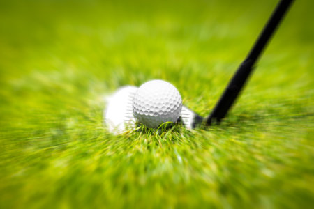 Closeup of hitting golf ball with golf iron club golf course wih motion blur effectの写真素材