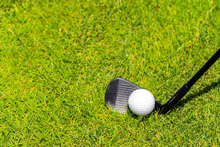 Golf iron club ready to hit a ball on green grass on golf courseの写真素材