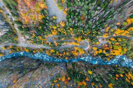 Top view of mountain road in forest with blue riverの写真素材