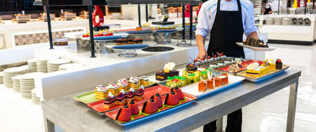 Serving staff sweet table pastries and cakes in the hotel barの写真素材