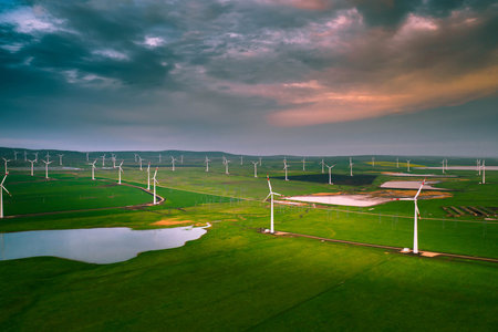 Wind turbine farm at sunset. Renewable energy concept. Producing alernative energy in windmills