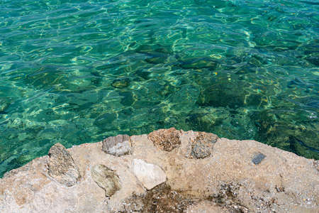Aquamarine transparent sea water without waves from a stone embankmentの写真素材