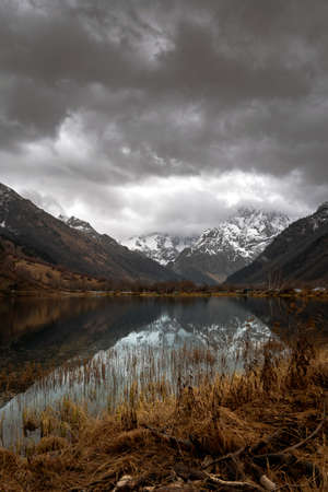 Mountain lake with dramaic sky at sunsetの写真素材