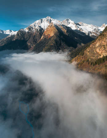 drone view of the fog in the valley between the mountains overlooking the beautiful skyの写真素材