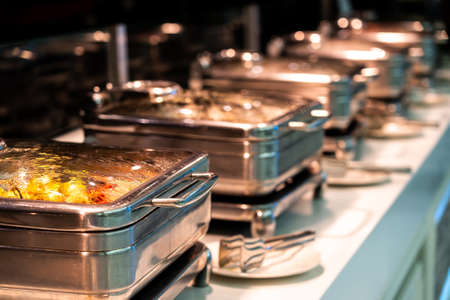 Catering buffet food with heated trays ready for service in hotel restaurantの写真素材