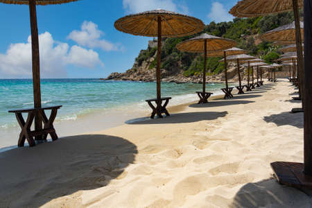Sun umbrellas by the surf in a beautiful bayの写真素材
