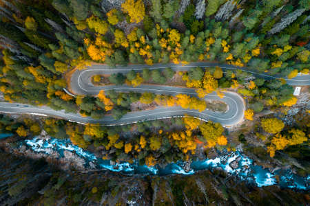 Top view of mountain road in forest with blue riverの写真素材