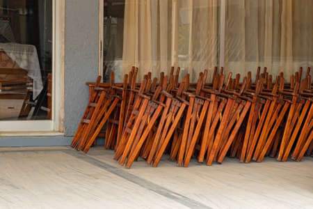 Stacked folding outdoor chairs at the cafe entranceの写真素材