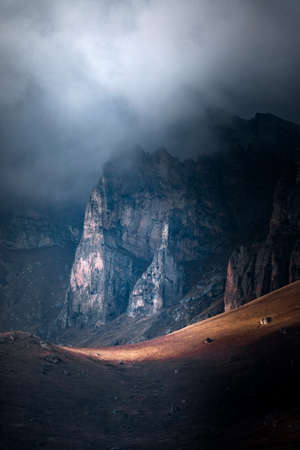 High mountain cliff with low clouds in Caucasus region in Russiaの写真素材