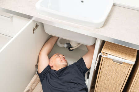 top view of repairing plumbing by a man under the sinkの写真素材
