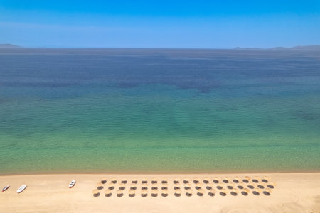 Beach perspective view of even rows of umbrellas and the surface of the sea as seen from a droneの写真素材