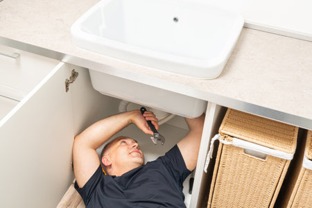 top view of a sink repair in a laundry room by an adult caucasian maleの写真素材