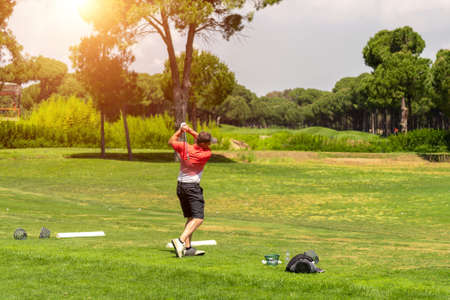 Golf player exercising on golf driving range before golf tournamentの写真素材