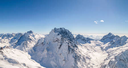 Shining mountain peak covered with snow against the blue skyの写真素材