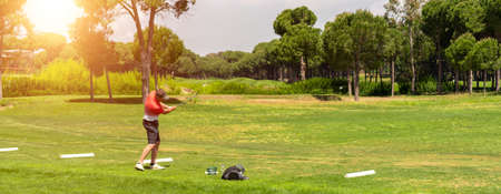 Golf player exercising on golf driving range before golf tournamentの写真素材