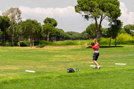 Golfer training his swing on golf driving rangeの写真素材