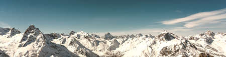 Panoramic view of winter snowy mountains in Caucasus region in Russia with blue skyの写真素材
