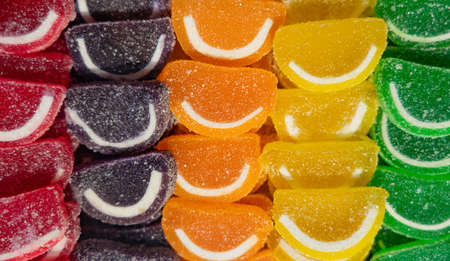 Slices of colored marmalade with smiles in sugarの写真素材