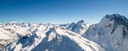 Mountain peak covered in snow under a clear blue skyの写真素材