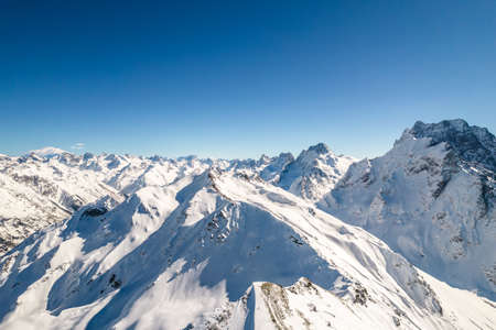 Mountain peak covered with snow against a blue skyの写真素材