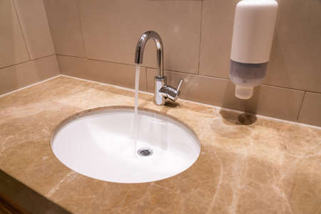 Sink with faucet in a hotel bathroom on a granite baseの写真素材