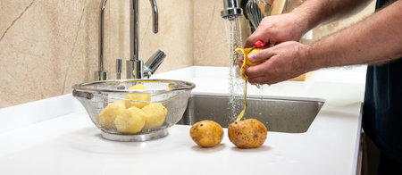 Peeling and cooking potatoes in the kitchen in the sink