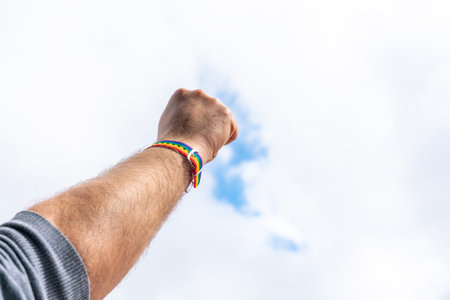 Hand clenched into a fist as a symbol of the fight for LGBT rights with a braceletの写真素材