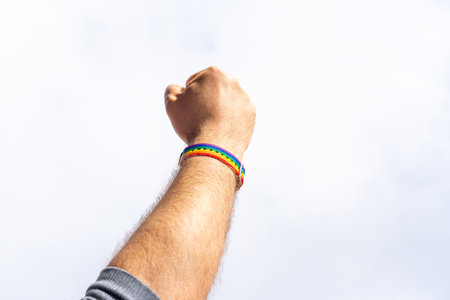 Isolate of a hand with an LGBT bracelet clenched into a fist as a symbol of the struggle for rightsの写真素材