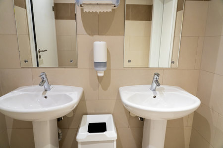 Reference photo of ceramic sinks in a public restroom with soap dish and wastebasketの写真素材