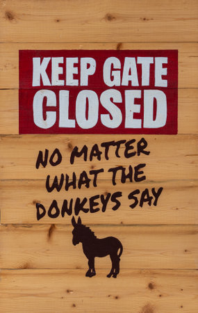 Funny sign on the enclosure with donkeys in the zooの写真素材