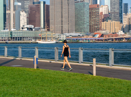 New York City, United States - September 18, 2022: Girl on a walk along the Brooklyn waterfront in shorts and a T-shirtのeditorial素材