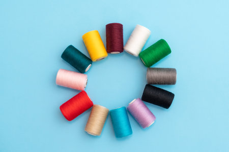 A circle in the form of a flower, colored spools with sewing threads as a concept of different people in one common businessの写真素材