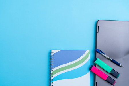 Several pens and markers with a notebook next to a laptop and phone. Concept of old and new...