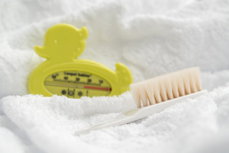 Baby bath thermometer brush and white towel cute bathing backgroundの写真素材