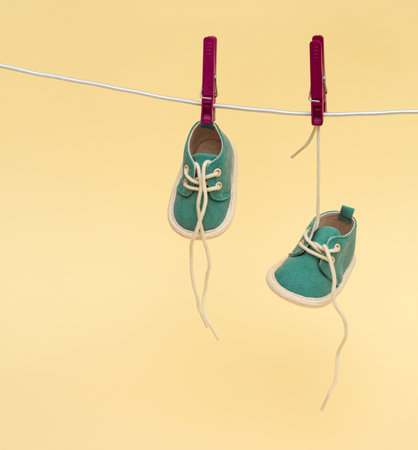 Baby shoes hanging on the clothesline. Newborn conceptの写真素材