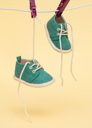 Baby shoes hanging on the clothesline. Newborn conceptの写真素材